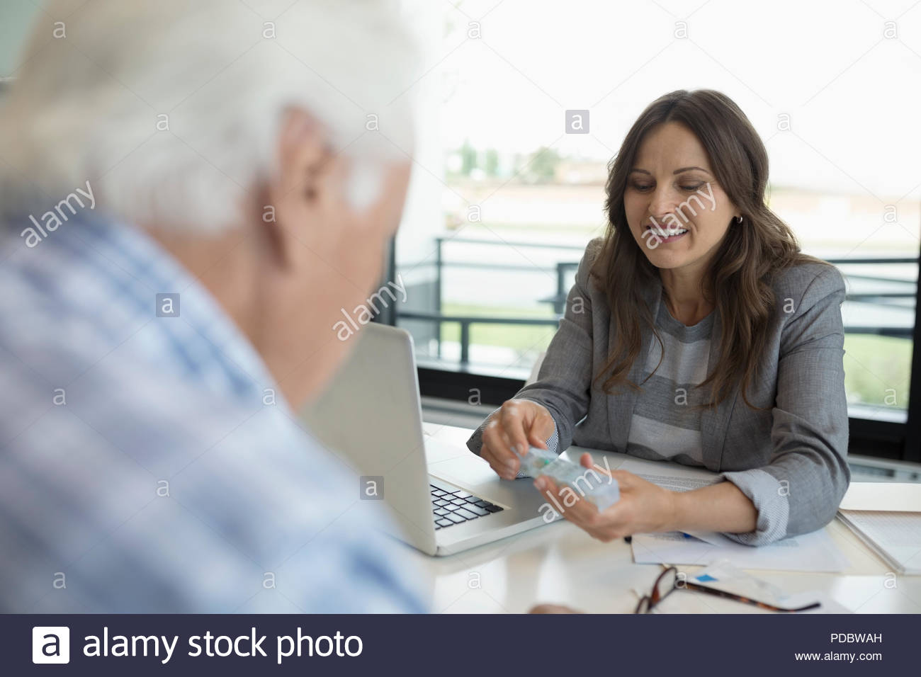 Ärztin Übersicht Medizin Pille, um ältere männliche Patienten in der Klinik Büro Stockfoto