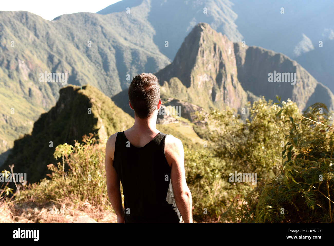 Mann von hinten betrachten Huayna Picchu Mountain und die antike Stadt von Machu Picchu, der "Verlorenen Stadt der Inkas" - UNESCO-Welterbe. Jun 2018 Stockfoto