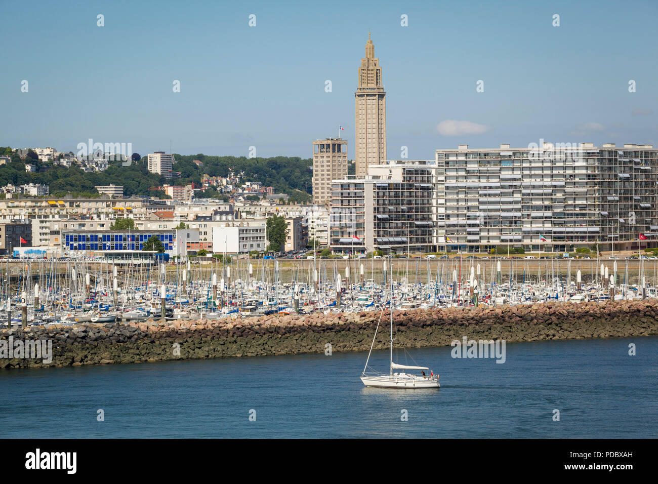 Ein Blick auf das Meer, die Kirche St. Joseph hinter der Residence de France Apartments und der Yachthafen von Le Havre in der Normandie, Frankreich Stockfoto