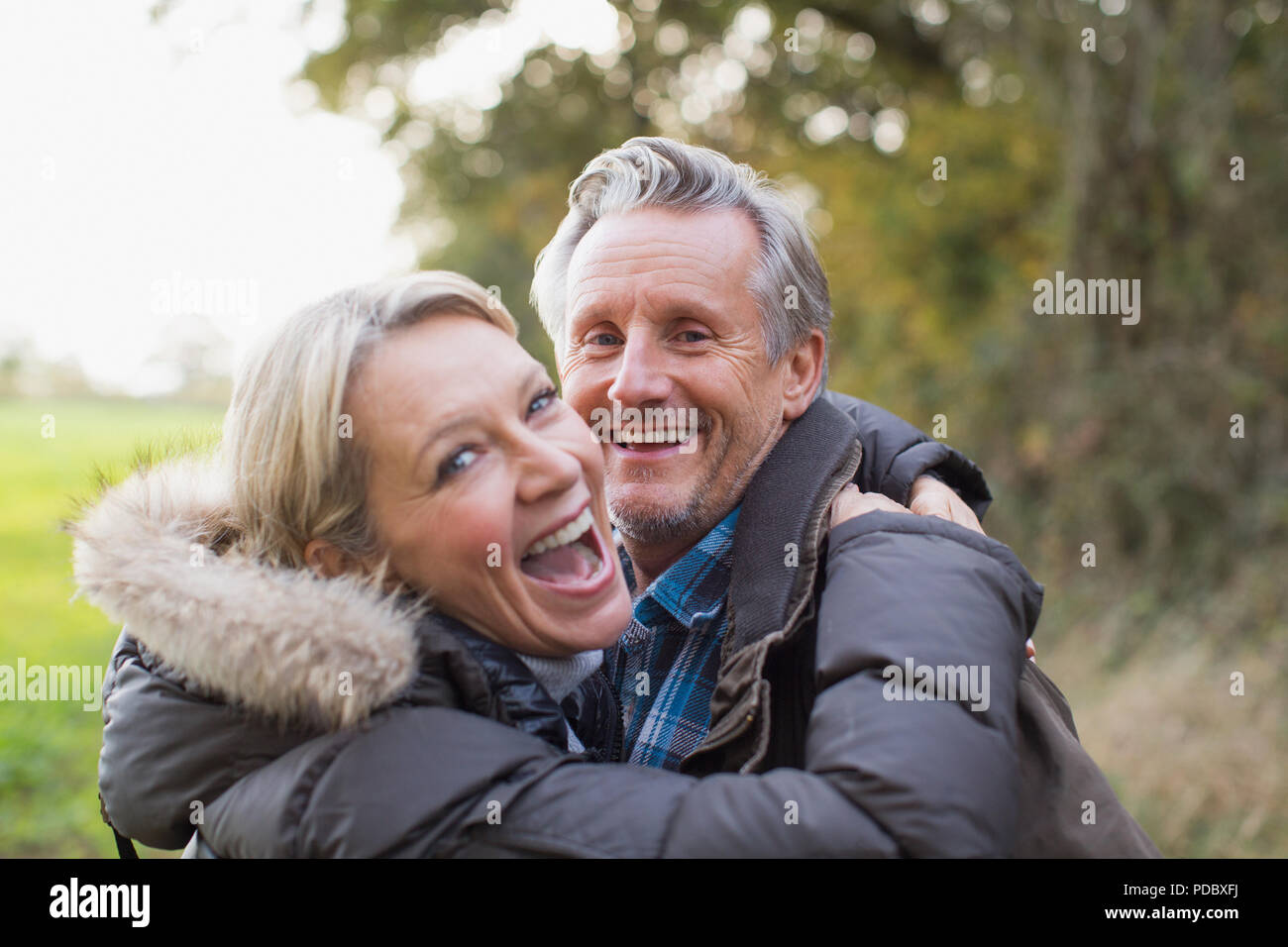 Portrait happy Reifes Paar umarmen in Park Stockfoto
