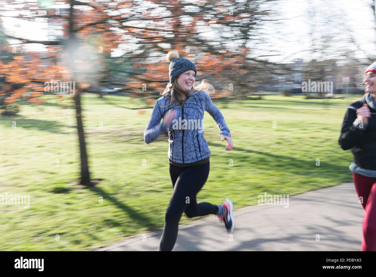 Lächelnd, zuversichtlich Läuferin im sonnigen Park Stockfoto