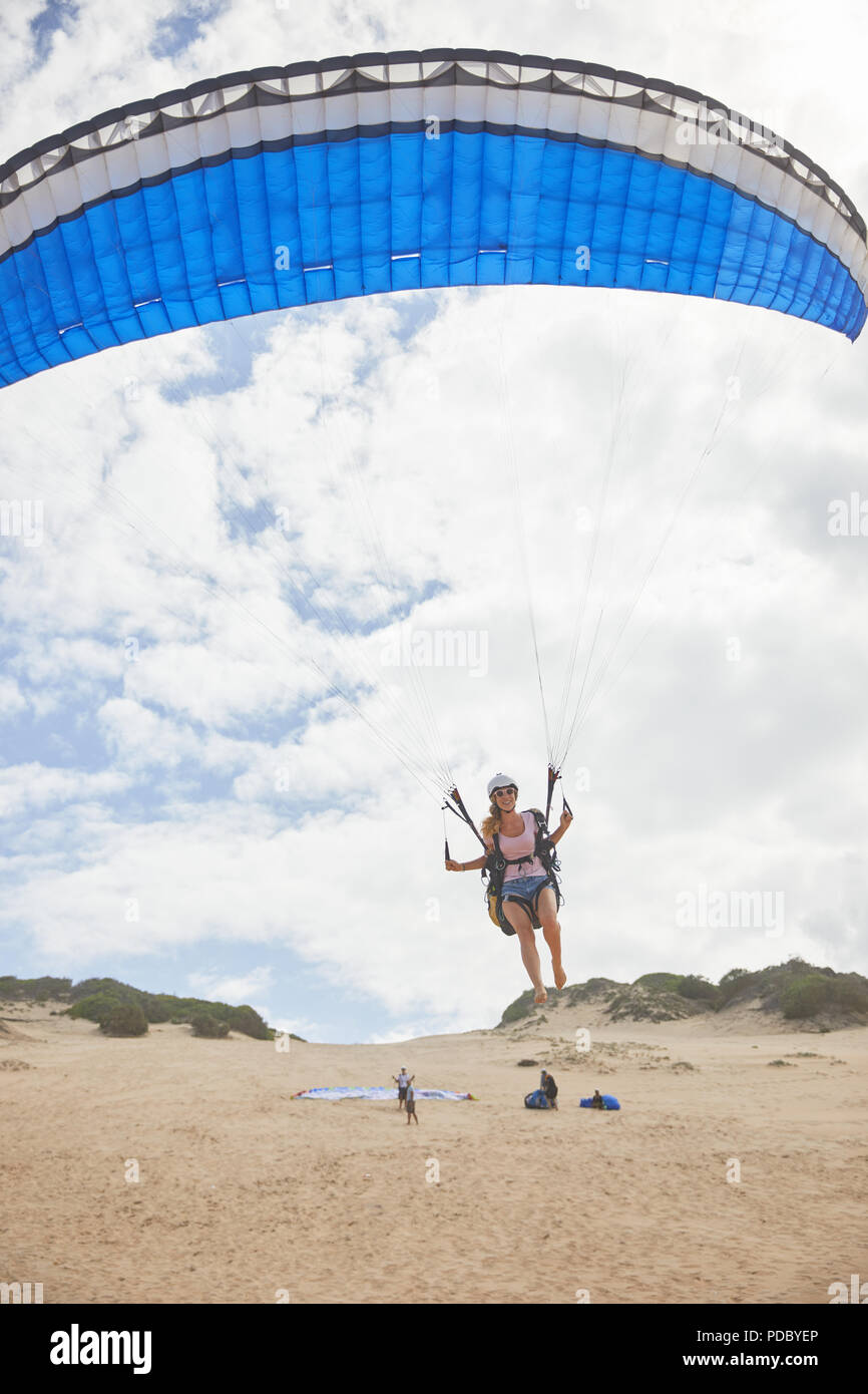 Weibliche Gleitschirm mit Fallschirm, die am Strand Stockfoto