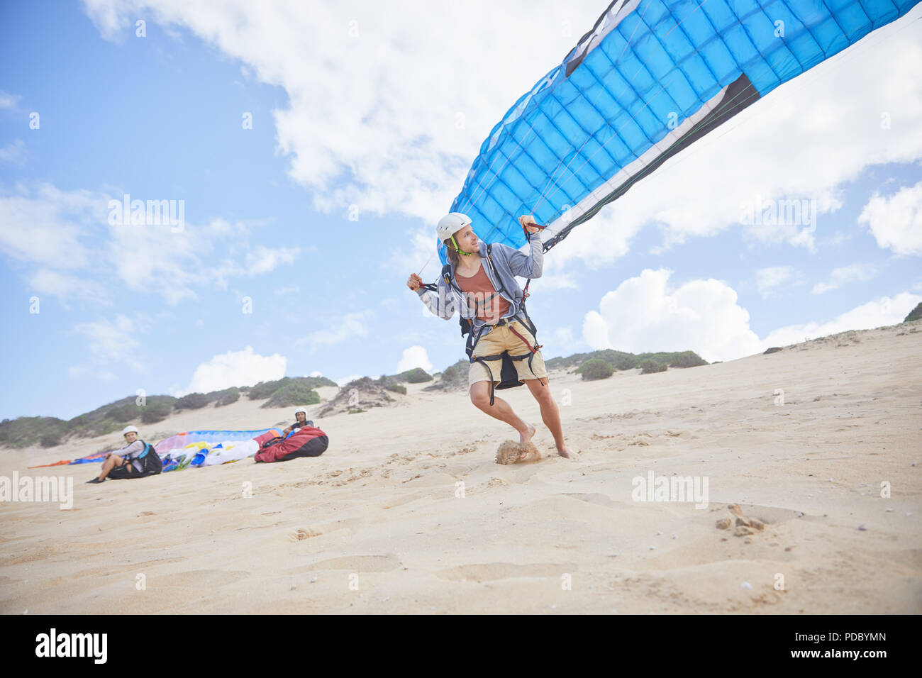 Männliche Gleitschirm mit Fallschirm am Strand Stockfoto