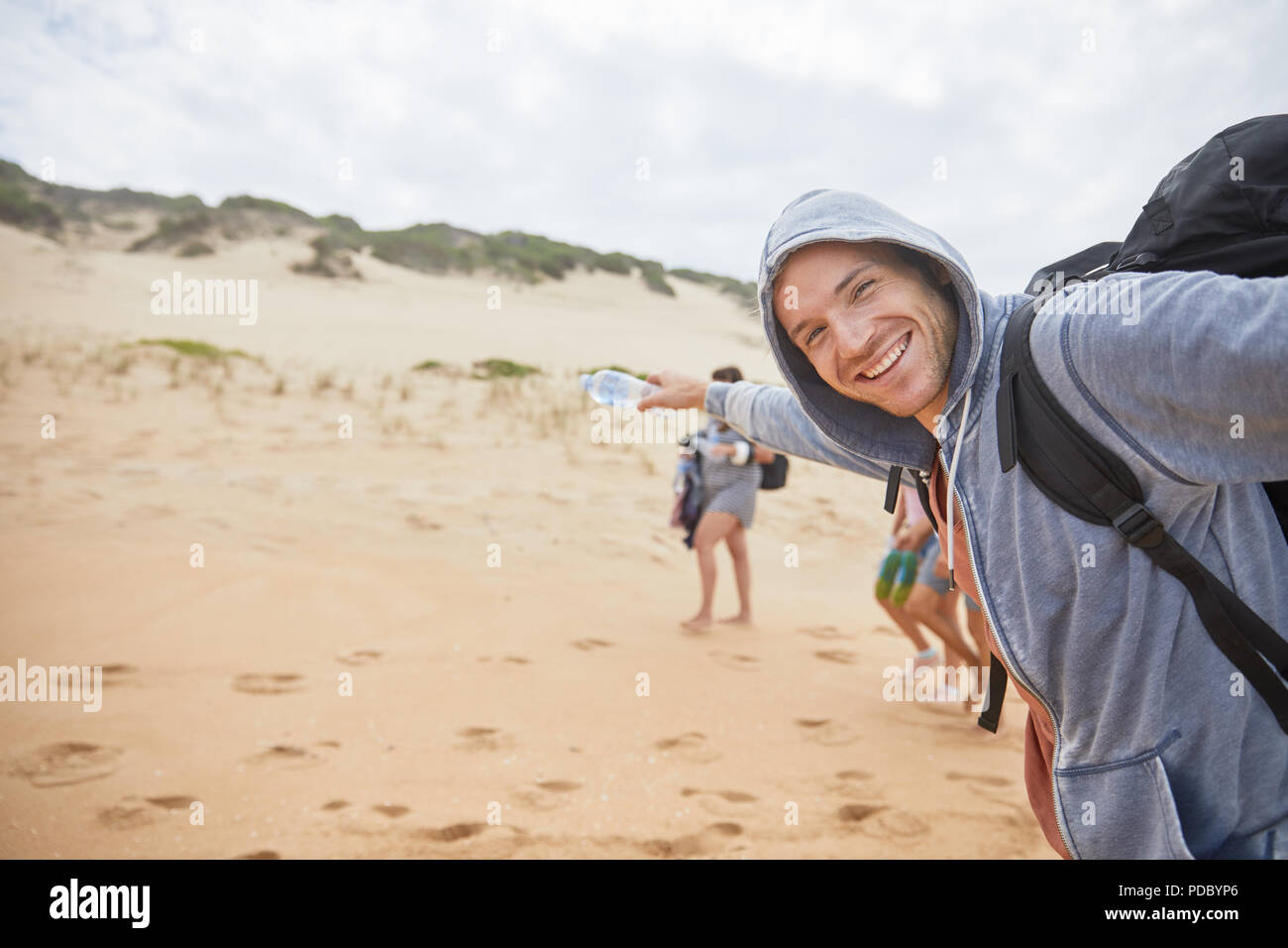 Portrait glückliche, unbeschwerte Menschen am Strand. Stockfoto