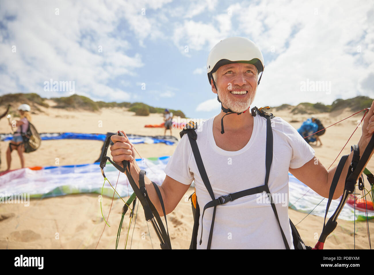 Reife männliche Gleitschirm auf Strand mit Ausrüstung Stockfoto