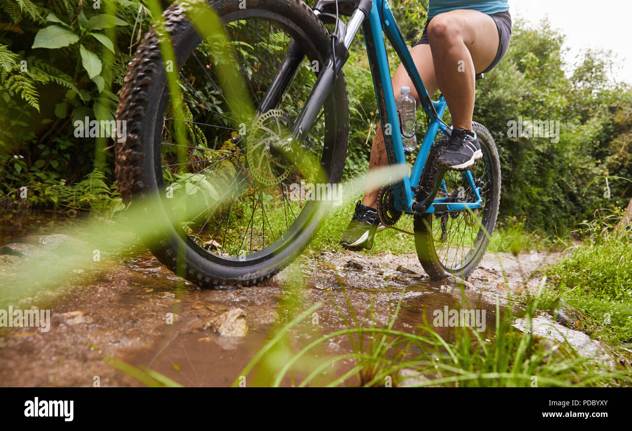 Frau Mountainbiken auf schlammigen Weg Stockfoto