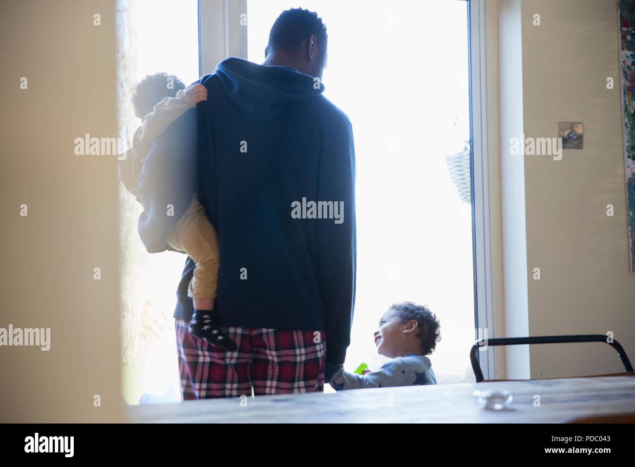 Vater und Söhne im Schlafanzug im Fenster Stockfoto