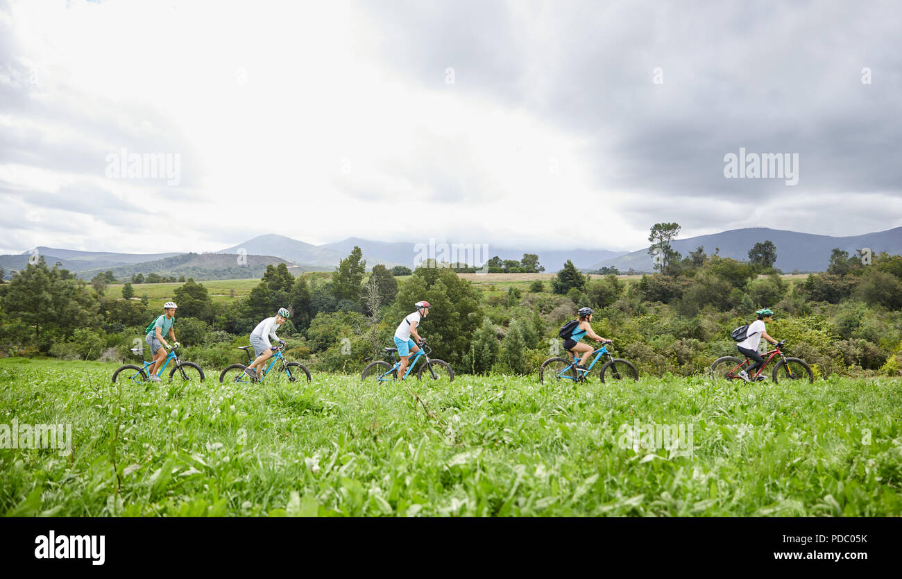 Freunde Mountainbiken im idyllischen, abgelegenen Feld Stockfoto