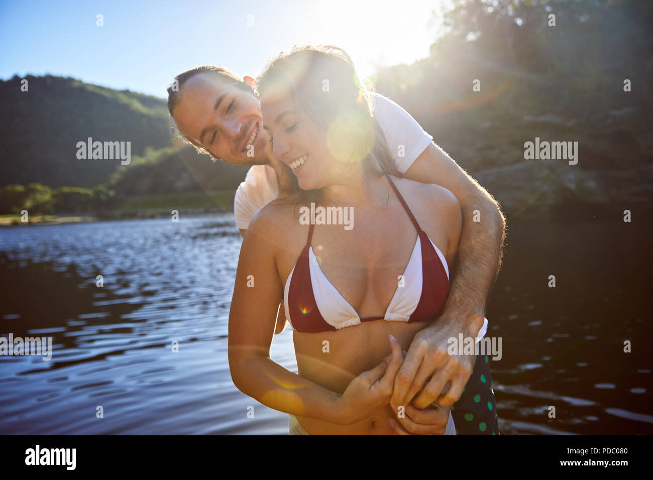 Zärtlich Paar umarmen am sonnigen Sommer See Stockfoto