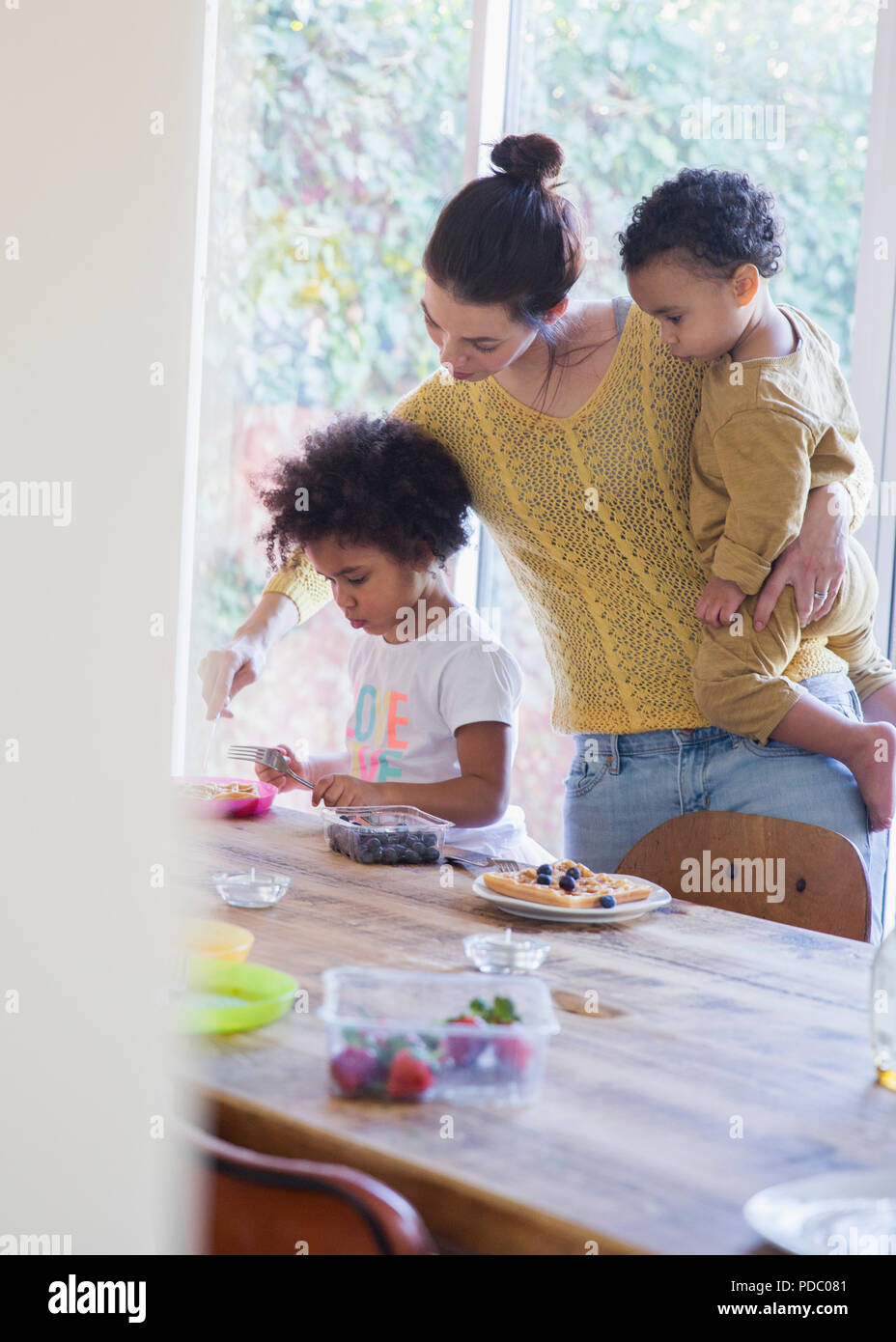 Mutter zur Tochter Frühstück am Tisch serviert Stockfoto