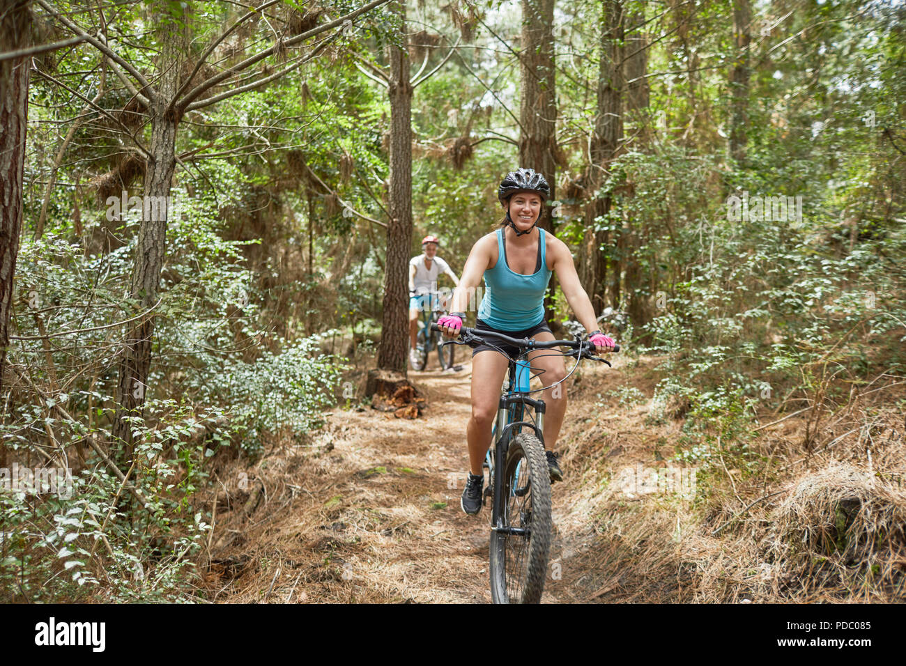 Sorglos Frau Mountainbiken auf Trail im Wald Stockfoto