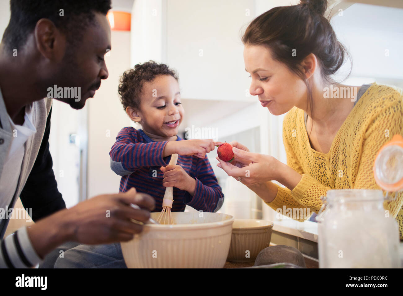 Eltern und neugierige Toddlersohn backen in der Küche Stockfoto