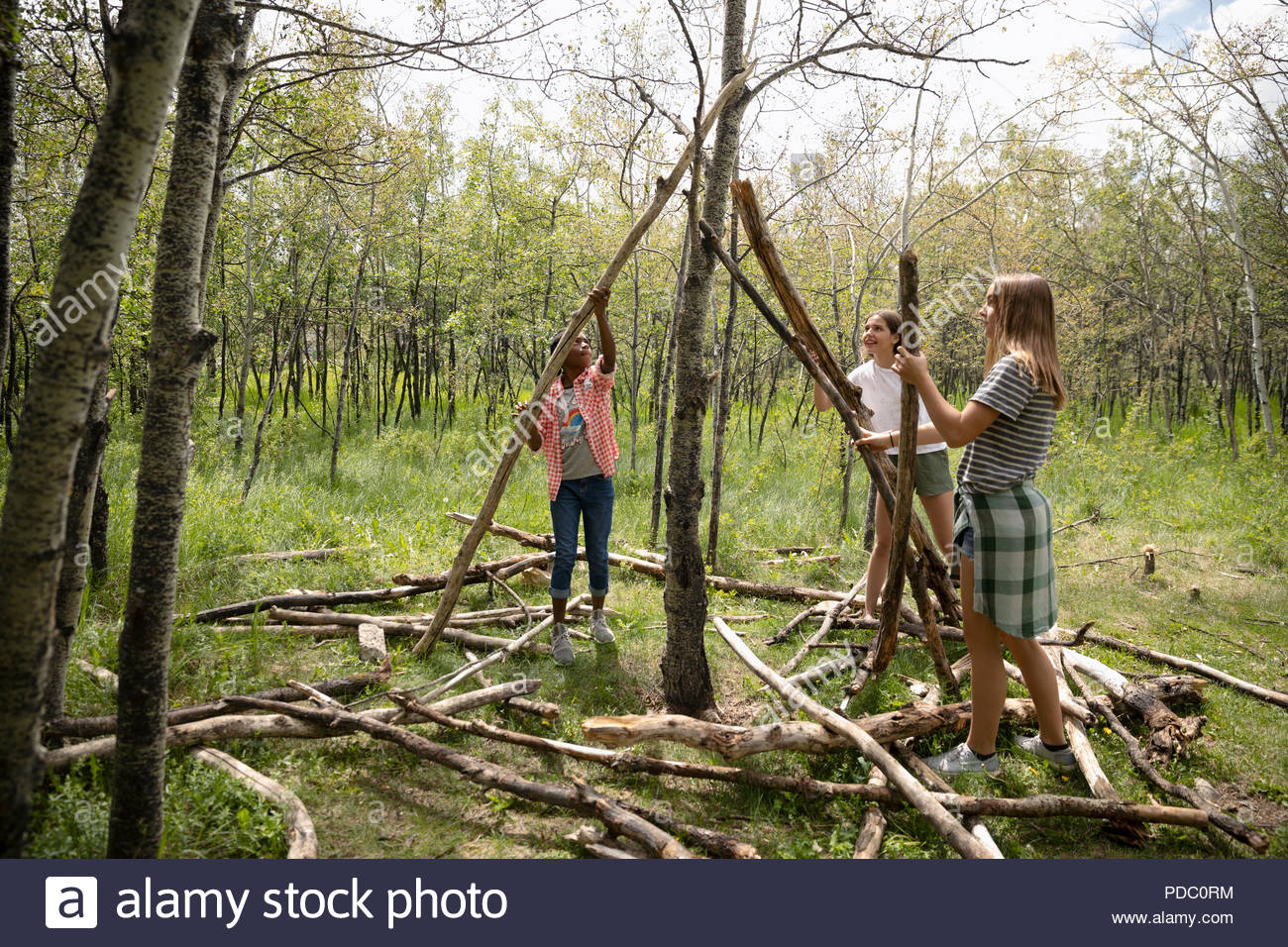 Tween Mädchen teepee in Wäldern mit Logs Stockfoto
