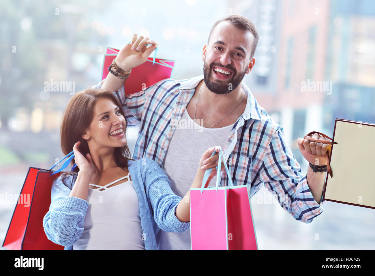 Portrait von glücklichen Paar mit Einkaufstüten nach dem Shopping in der Stadt Stockfoto