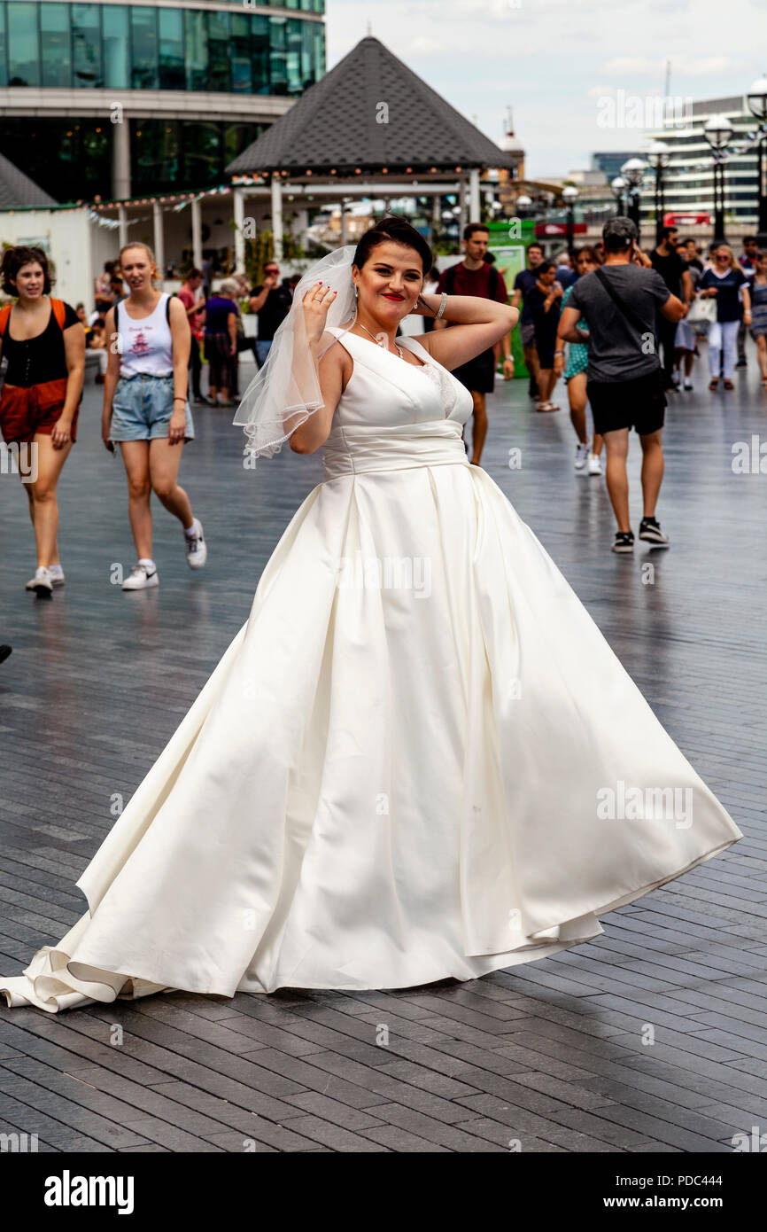 Eine Braut stellt für eine Hochzeit Fotografieren außerhalb der City Hall, London, England Stockfoto