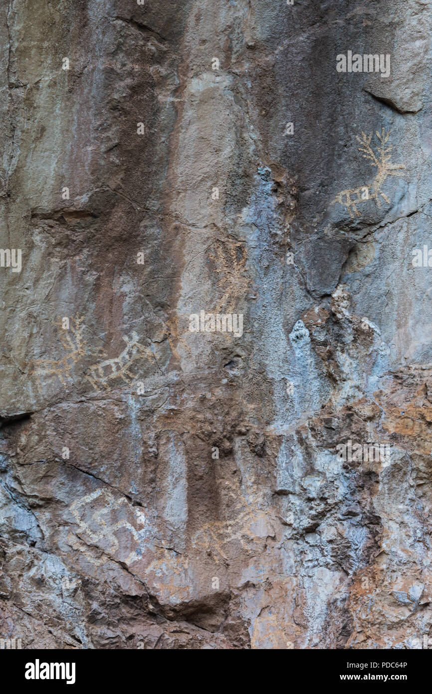 Alte prähistorische archäologische rock Zeichnungen von Jagdszenen angezeigt Rehe Hirsche, Reiter und symbolische Kult Hakenkreuze an Lipci, Montenegro. Stockfoto