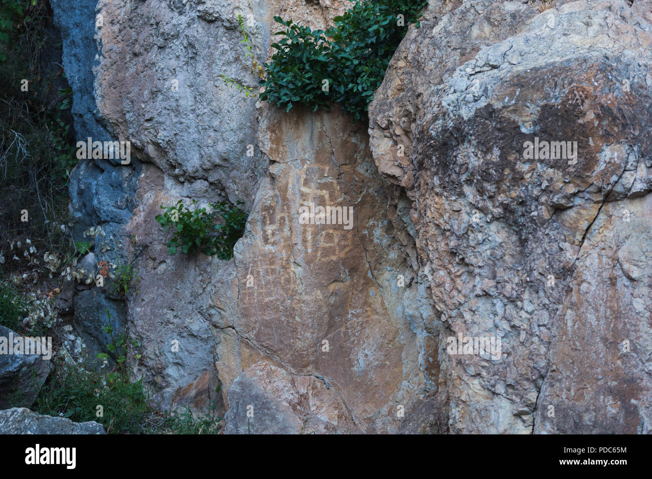 Alte prähistorische archäologische rock Zeichnungen von Jagdszenen angezeigt Rehe Hirsche, Reiter und symbolische Kult Hakenkreuze an Lipci, Montenegro. Stockfoto
