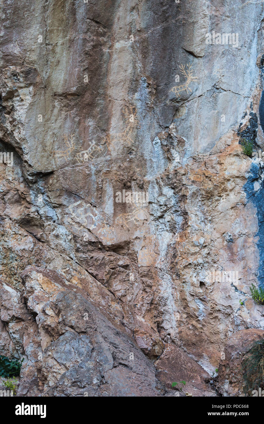 Alte prähistorische archäologische rock Zeichnungen von Jagdszenen angezeigt Rehe Hirsche, Reiter und symbolische Kult Hakenkreuze an Lipci, Montenegro. Stockfoto