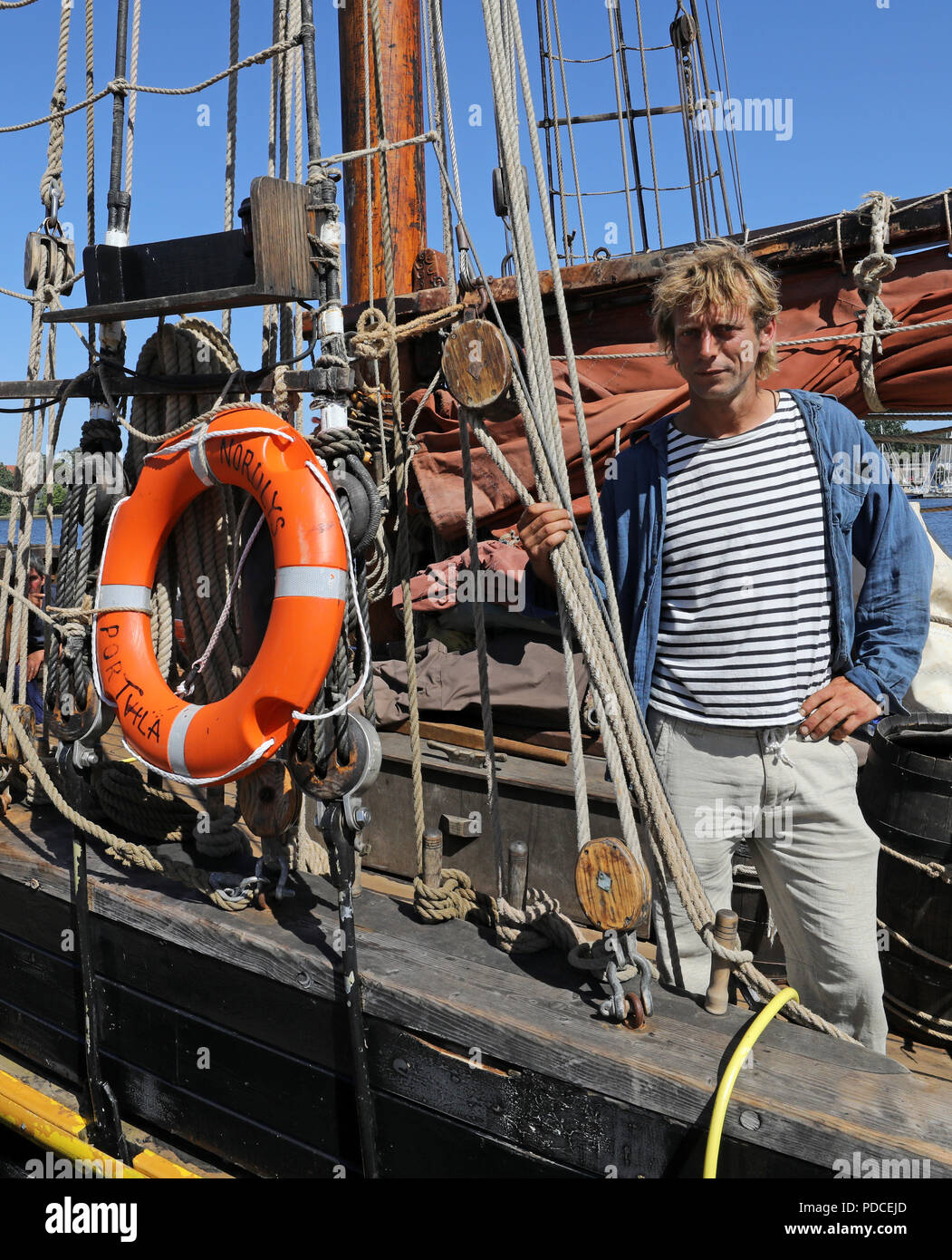 Rostock, Deutschland. 07 Aug, 2018. Kapitän Lammert Osinga steht an Bord seiner "Nordlys" (Norwegisch für Northern Lights). Die wohl ältesten Handelsschiff der Welt ist eine exotische unter den Gästen der Hanse Sail, die am 09. August 2018 eröffnet wird: 1873 erbaut, das Schiff hat keine Hilfsmotor und kann deshalb nicht nehmen Sie Teil an den Kreuzfahrten. In diesem Jahr, es war ziemlich rot Wein an Bord produziert. Der cutter Segeln unter der Flagge Vanuatu ist, die im Auftrag von Fairtrade. Quelle: Bernd Wüstneck/dpa/Alamy leben Nachrichten Stockfoto