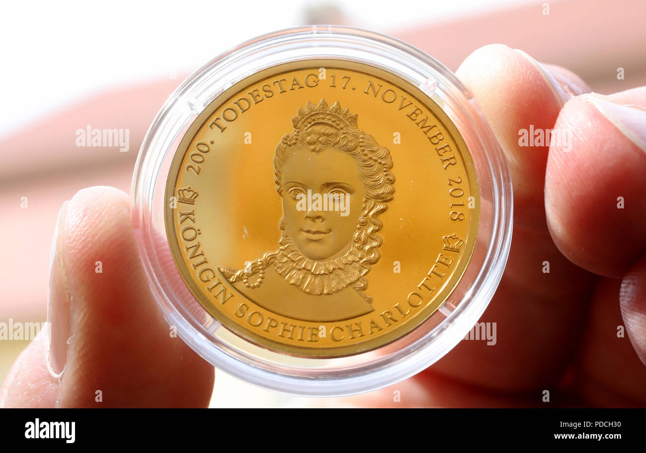 08. August 2018, Deutschland, Mirow: Eines der streng limitierten Gedenkmünzen in Gold zum Gedenken an den 200. Jahrestag des Todes der britischen Königin Sophie Charlotte (1744-1818) zeigt Michael Knippschild von Euromint (Bochum), nachdem sie bei einem Empfang in der '3 Königin Palais' im Kavaliershaus vorgestellt wurden. Der Monarch kam von Mecklenburg-Strelitz und fuhren in Großbritannien und Irland für 57 Jahre. Sie gehört zu den Gründern der heutigen britischen königlichen Familie gezählt. (Auf "spezielle Münzen für Vorfahren der englischen königlichen Familie" der 08.08. 2018) Foto: Bernd Wüstneck/dpa Stockfoto