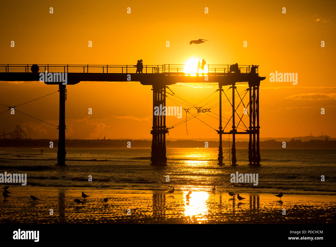 Menschen beobachten Sonnenuntergang von Salburn Victirian's Pier. Saltburn am Meer, North Yorkshire, England. Vereinigtes Königreich. August 2018. Stockfoto