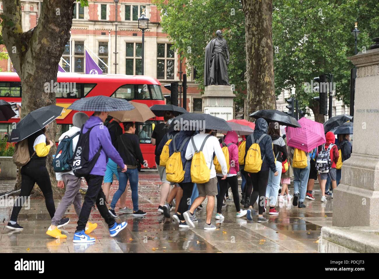 London, 9. August 2018: Touristen in Parliamnet Square Schutz vor dem Regen unter Regenschirmen. Credit: Claire Doherty/Alamy leben Nachrichten Stockfoto