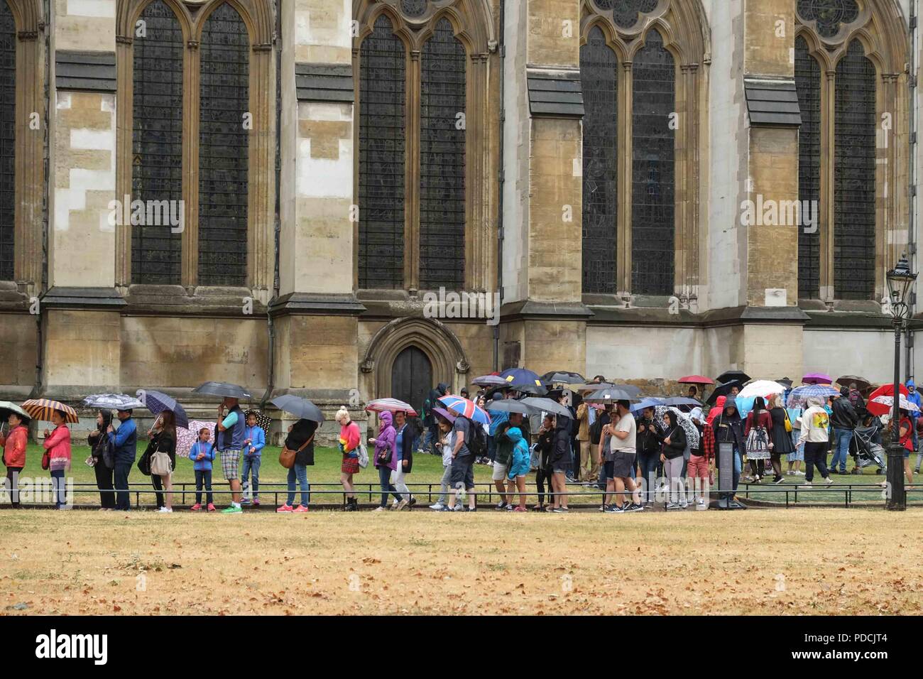 London, 9. August 2018: Die Besucher Schlange an der Westminster Abbey bei schwerem Regen. Credit: Claire Doherty/Alamy leben Nachrichten Stockfoto