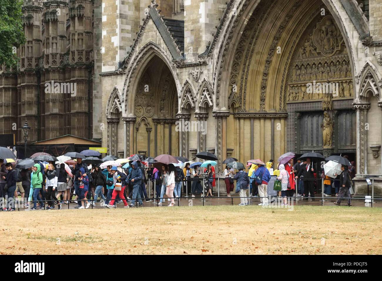 London, 9. August 2018: Die Besucher Schlange an der Westminster Abbey bei schwerem Regen. Credit: Claire Doherty/Alamy leben Nachrichten Stockfoto