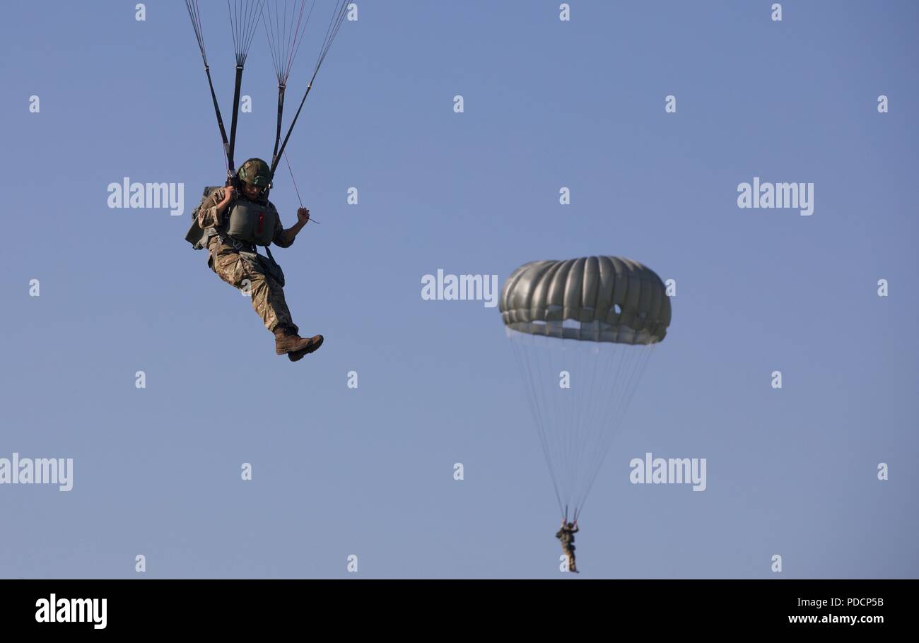 Zwei britische Fallschirmjäger Fallschirm über Ihre MC-6 Fallschirm auf Schloss Drop Zone bei Leapfest 2018 West Kingston, RI., 5. August 2018. Leapfest ist der größte und am längsten bestehende, internationale statische Linie Fallschirm Training und Wettbewerb veranstaltet vom 56. Truppe den Befehl, Rhode-Island Army National Guard hohe technische Ausbildung zu fördern und Korpsgeist innerhalb der internationalen Gemeinschaft in der Luft. (U.S. Armee Foto: Staff Sgt. Austin Berner) Stockfoto