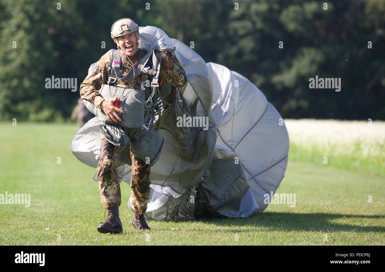 Eine Italienische Fallschirmjäger läuft zum X auf Schloss Drop Zone mit seinem MC-6 Fallschirm während Leapfest 2018 West Kingston, RI., 5. August 2018. Leapfest ist der größte und am längsten bestehende, internationale statische Linie Fallschirm Training und Wettbewerb veranstaltet vom 56. Truppe den Befehl, Rhode-Island Army National Guard hohe technische Ausbildung zu fördern und Korpsgeist innerhalb der internationalen Gemeinschaft in der Luft. (U.S. Armee Foto: Staff Sgt. Austin Berner) Stockfoto