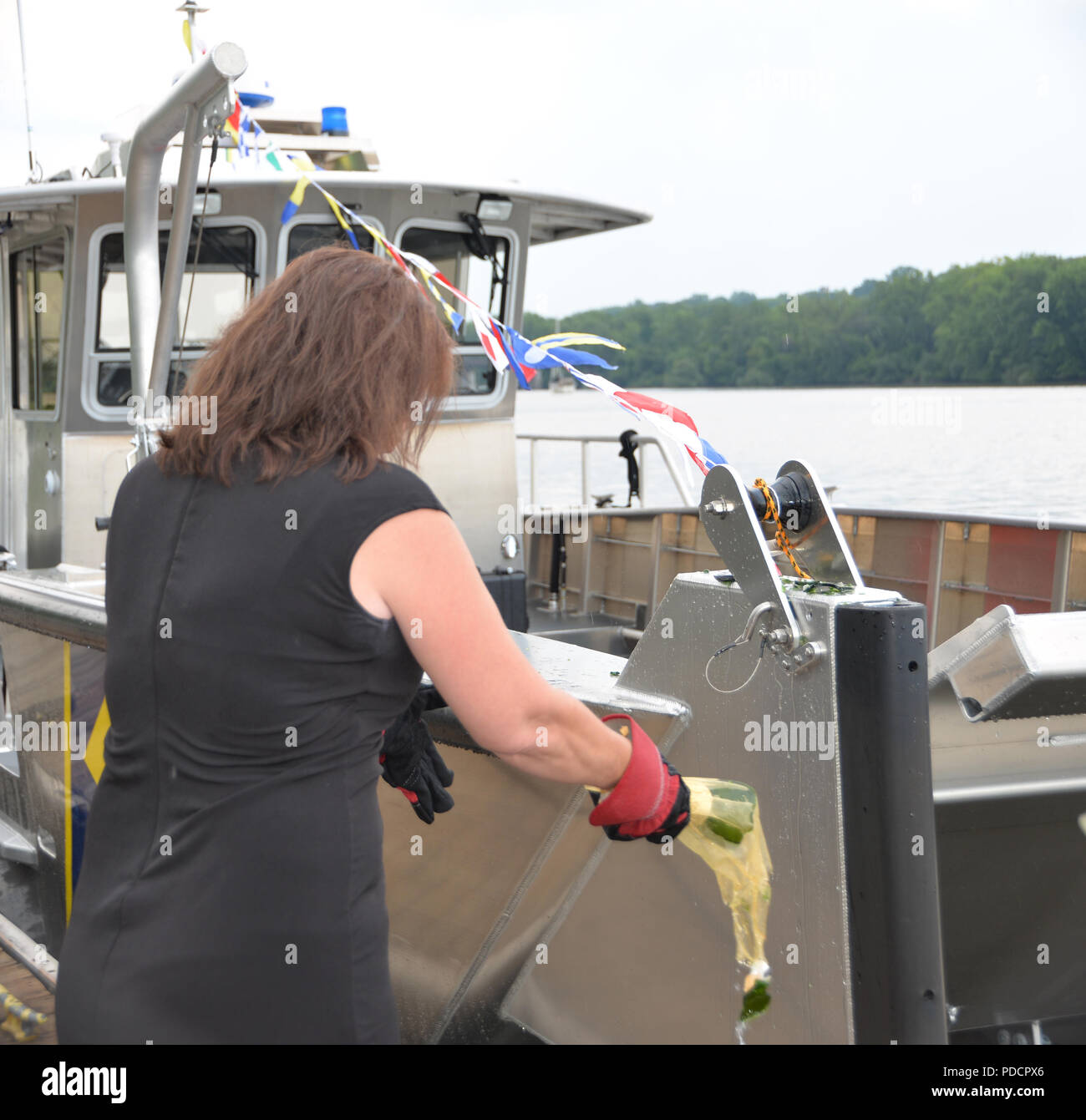 New York State Divison von Militär und Marine Angelegenheiten Mitarbeiter Lisa Bogardus, der Sponsor von New York Naval Miliz Patrouillenboot LC-350 zertrümmert, eine Flasche Sekt gegen das Boot während der Taufe am Jennings Landung Park in Albany, N.Y. am Dienstag, August 7. LC-350 ist ein 35-Fuß lang, Landing Craft stil Boot von Munson, ein Staat Washington gemacht. Das Boot kann 27 Personal führen, drei Tonos von Lieferungen, oder ein kleines Fahrzeug. (U.S. Army National Guard Foto vom Kapitän Jean Marie Kratzer) Stockfoto