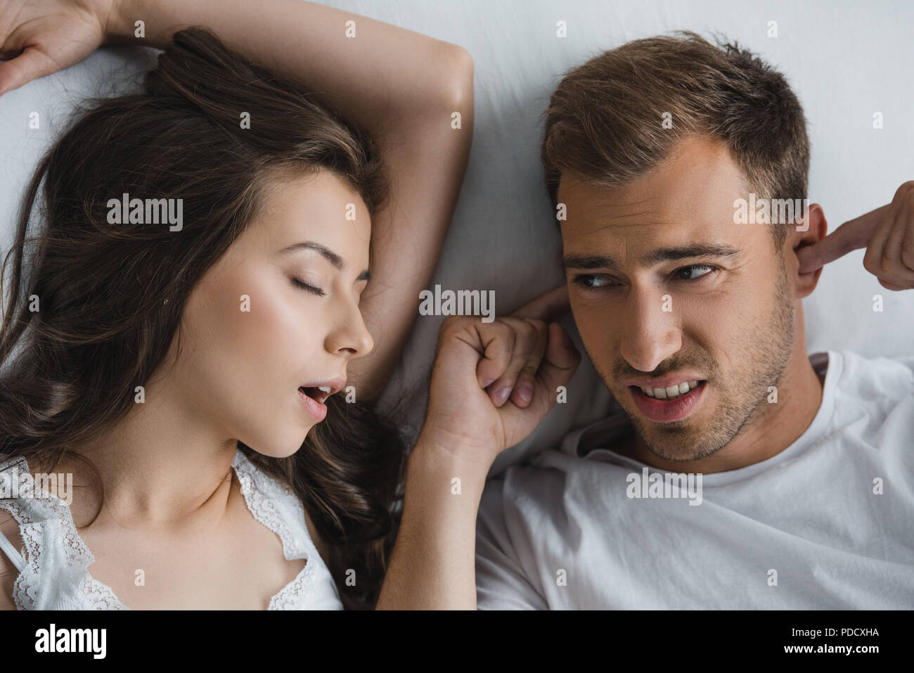 Blick von oben auf die man schließen, die Ohren und Blick auf das Schnarchen Frau im Bett Stockfoto