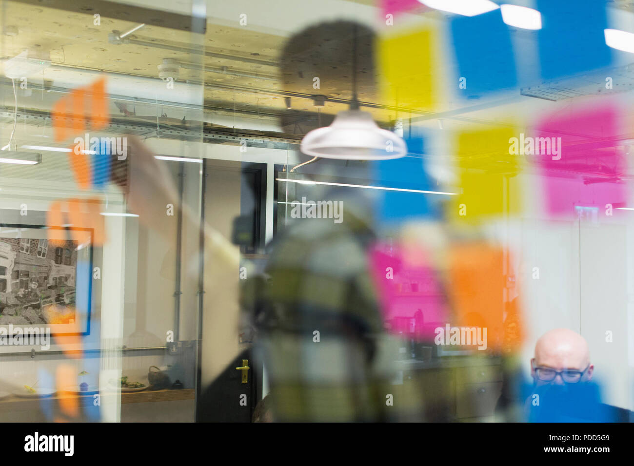 Kreative Geschäftsleute Brainstorming hinter Haftnotizen auf Office Fenster Stockfoto