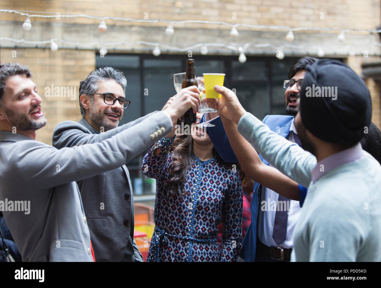 Freunde toasten Bier und Cocktails bei Party auf der Terrasse Stockfoto