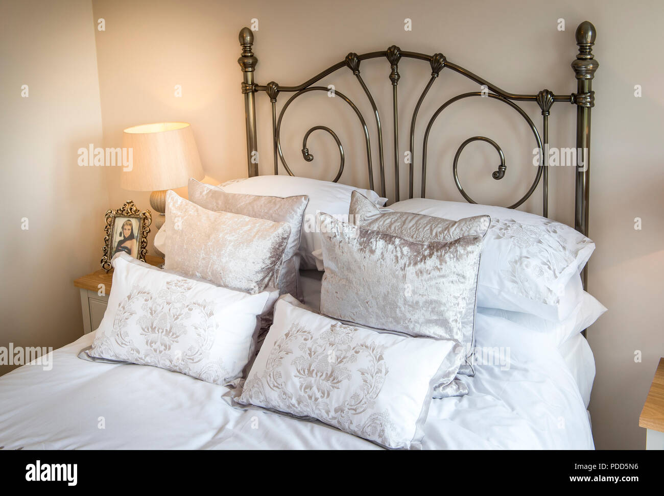 Reich verzierten schmiedeeisernen Kopfteil auf ein Doppelbett. Stockfoto