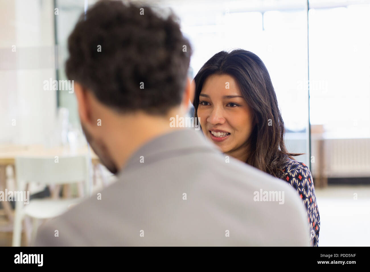 Lächelnd Geschäftsfrau im Gespräch mit Kollege im Büro Stockfoto