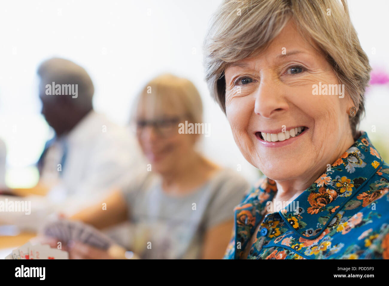 Porträt Lächeln, selbstbewusste ältere Frau Karten spielen mit Freunden Stockfoto