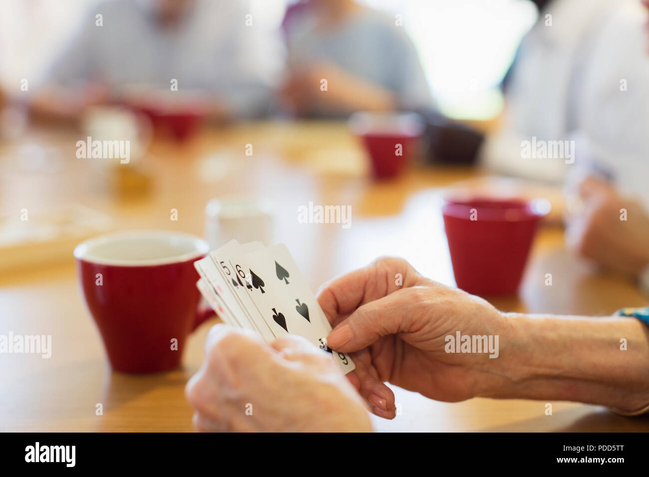Nahaufnahme der älteren Frau Karten spielen mit Freunden im Community Center Stockfoto