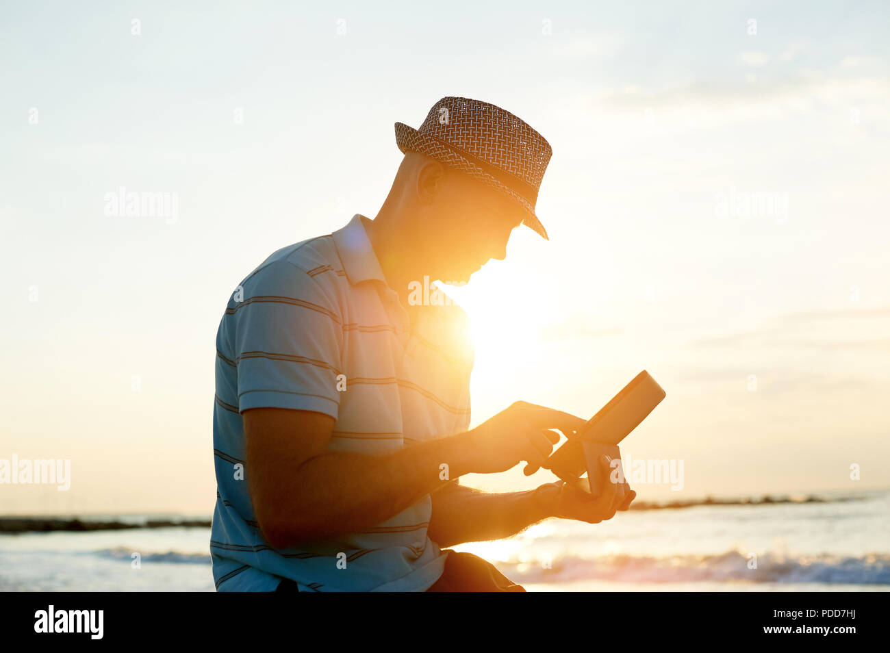 Älterer Mann bei der Arbeit auf seinem Laptop am Strand bei Sonnenuntergang, Freiberufler Konzept in Reisen Stockfoto Älterer Mann bei der Arbeit auf seinem Laptop am Strand bei Sonnenuntergang, Freiberufler Konzept in Reisen Stockfoto