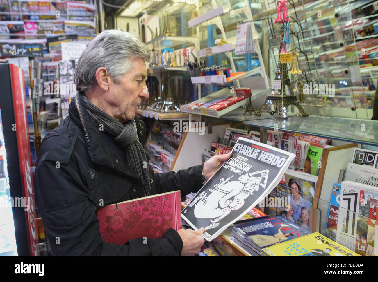 Januar 6, 2016 - Paris, Frankreich: Portrait von Ray Cosperec, der gerade die neueste Ausgabe von Charlie Hebdo gekauft mit einem mörderischen monotheistischen Gott auf dem Deckblatt. Gedenken de l'Sprengstoffanschlag contre Charlie Hebdo, un ein Apres l'attaque. *** Frankreich/KEINE VERKÄUFE IN DEN FRANZÖSISCHEN MEDIEN *** Stockfoto