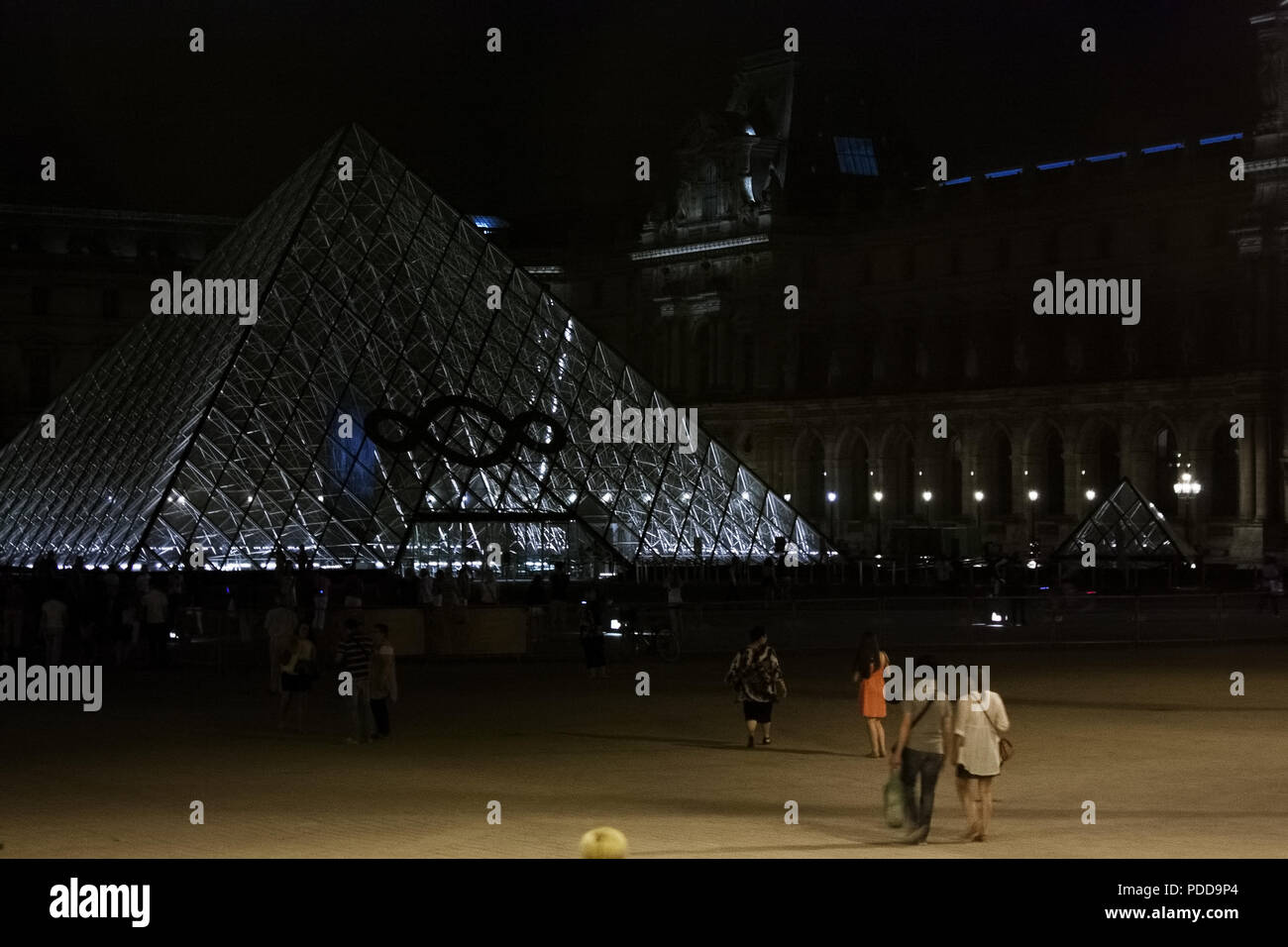 Louvre Pyramiden bei Nacht mit Touristen, Paris Stockfoto