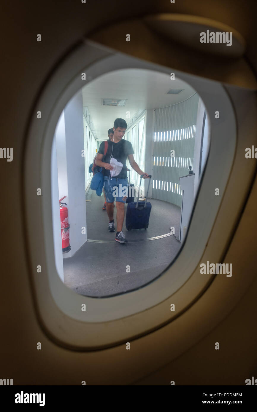 Fahrgast mit rollenden Koffer Tasche Gepäck boarding Flugzeug von im Flugzeug Stockfoto