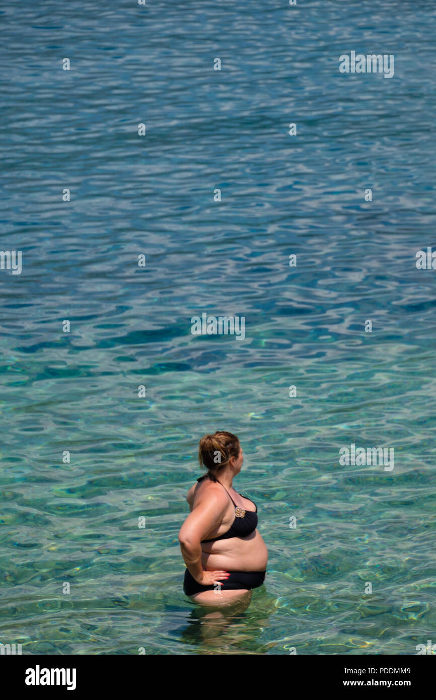 Übergewichtige Frau am Strand Stockfoto