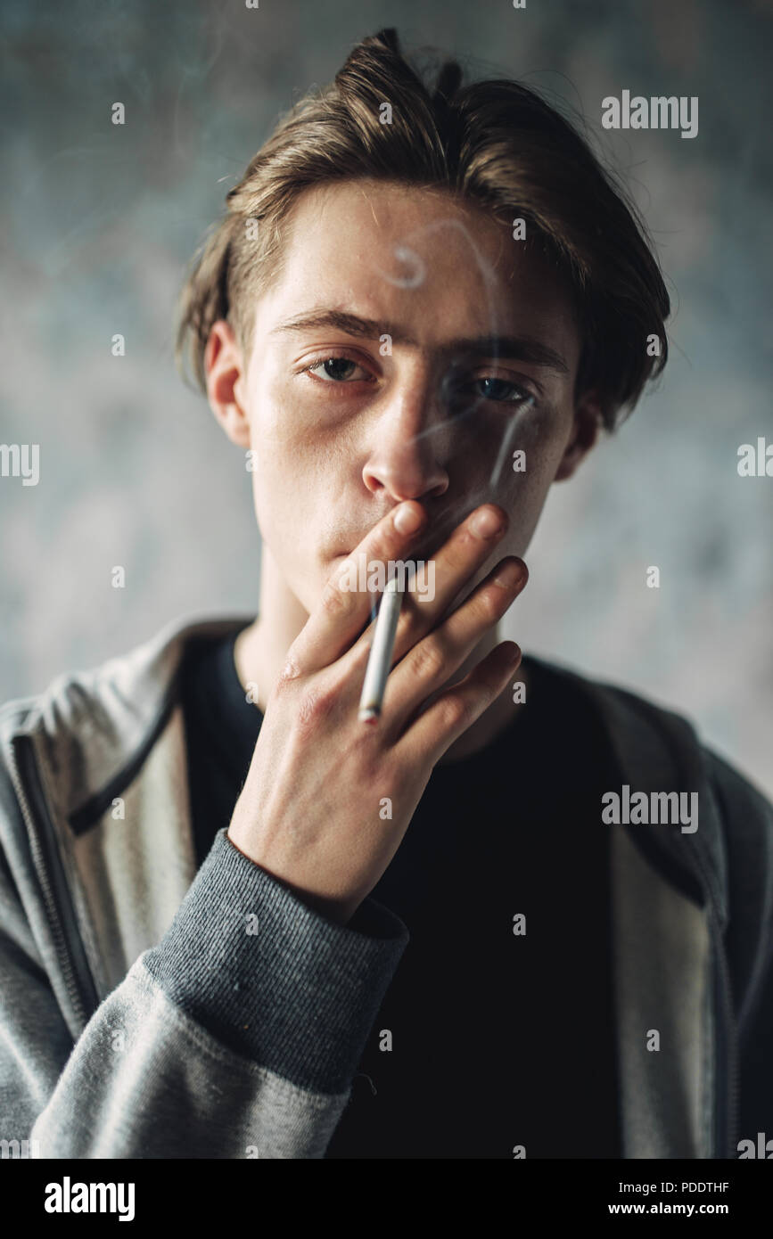 Junger Mann rauchen Zigarette, sucht Konzept Stockfoto