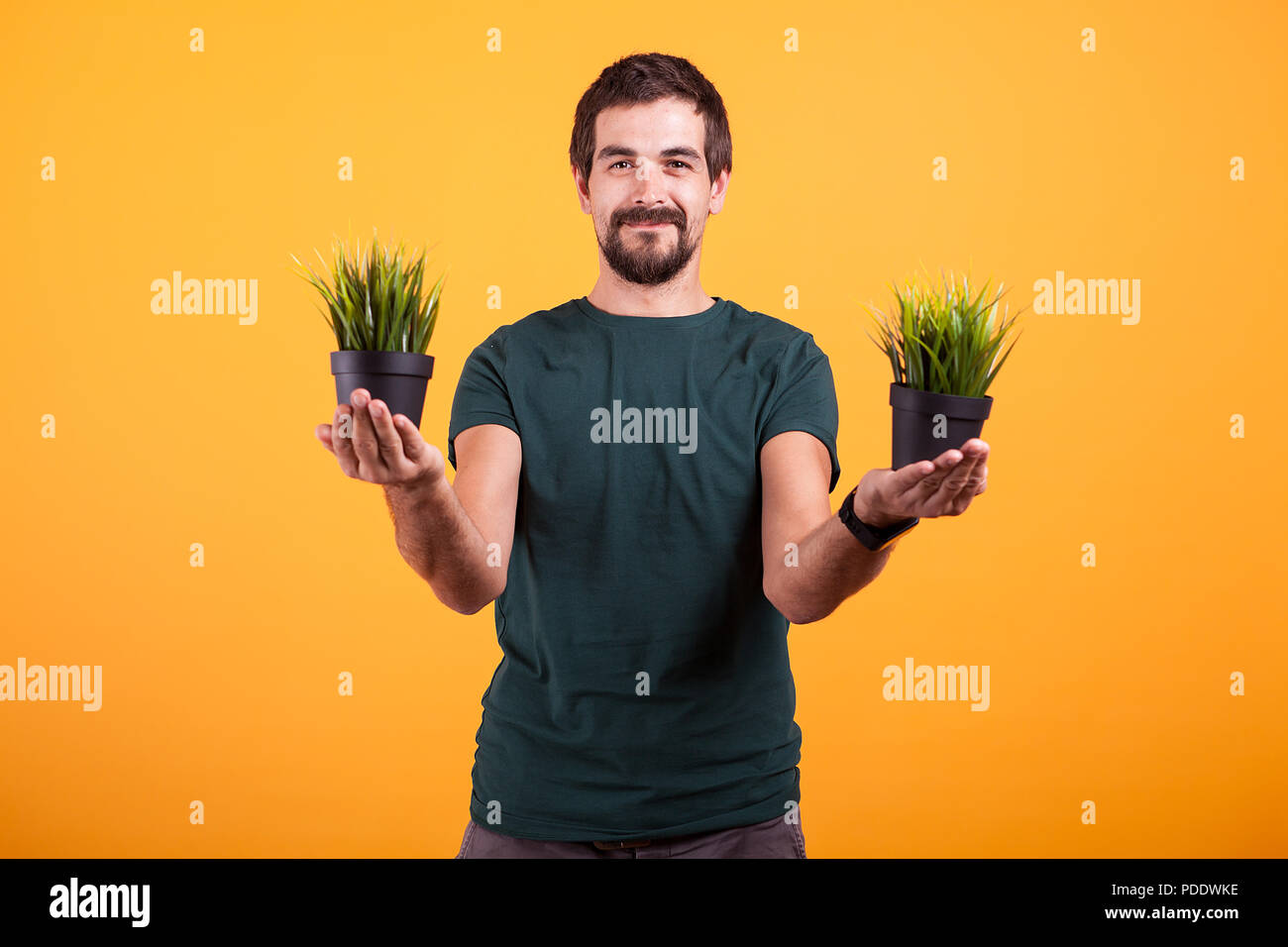Ruhe Konzept Bild des entspannten Mann hält zwei Töpfe von Gras in seine Hände Stockfoto