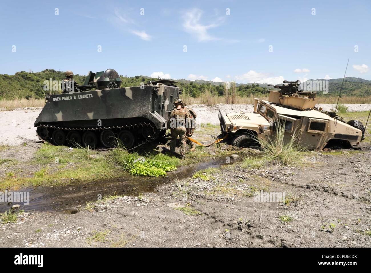 Philippinische Soldaten helfen Soldaten der US-Armee aus schwere Waffen Platoon, d Unternehmen, 1.Bataillon, 21 Infanterie Regiment, 2 Infantry Brigade Combat Team, 25 Infanterie Division, ihre festgefahrenen Fahrzeugs bei einem trockenen - Feuer Probe wieder für die kommende kombinierte Waffen live-fire Übung am Oberst Ernesto Ravina Air Base, Tarlac, Philippinen, 12. Mai 2018, als Teil der Übung Balikatan. Die philippinische Armee Soldaten wurden unter Verwendung einer M113 Schützenpanzer ein high-mobility Multipurpose Radfahrzeug zu extrahieren. Übung Balikatan, in seiner 34. Iteration, ist eine jährliche US-Philippin Stockfoto