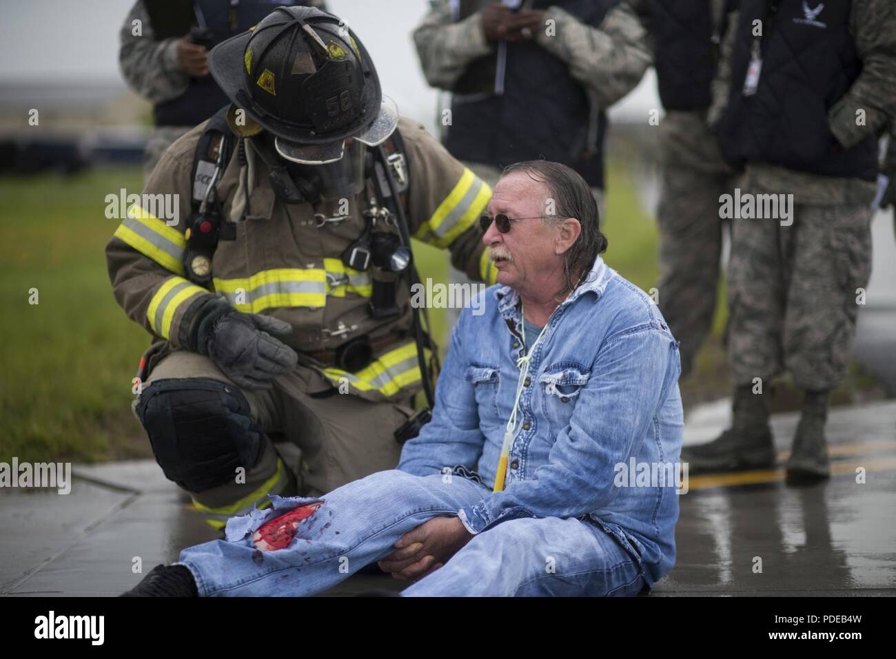 Ein 914Th Air Refuelling Flügel Fire Fighter kümmert sich um das Opfer eines simulierten Flugzeug Absturz bei einer Massenkarambolage Antwort Übung, 19. Mai 2018, Niagara Falls Luft finden Station, NEW YORK, die Stute ist entworfen, um Beurteilen und Notfallplan des Militärs Installation zu bewerten sowie die Wirksamkeit der lokalen First Responder. Stockfoto