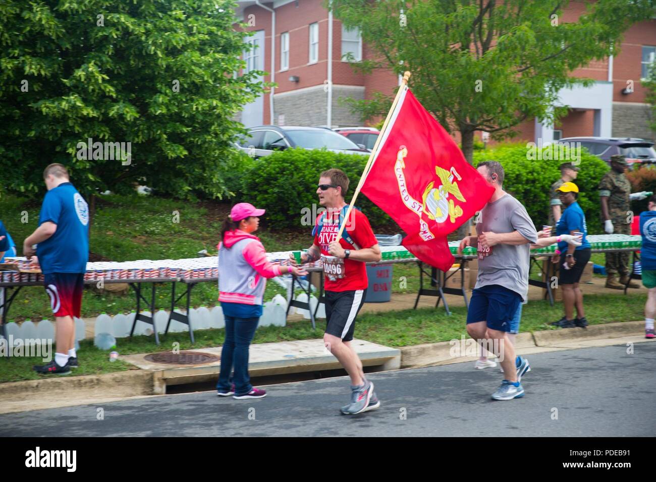 Freiwillige Hand, Wasser zu Teilnehmer Semper 5ive Rennen der 11. jährlichen Marine Corps historischen (MCHH) laufen in Fredericksburg, Virginia, 20. Mai 2018. Die MCHH lockt über 8.000 Teilnehmer und beinhaltet die Devil Dog Double und Marine Corps Semper 5ive Rennen. Stockfoto