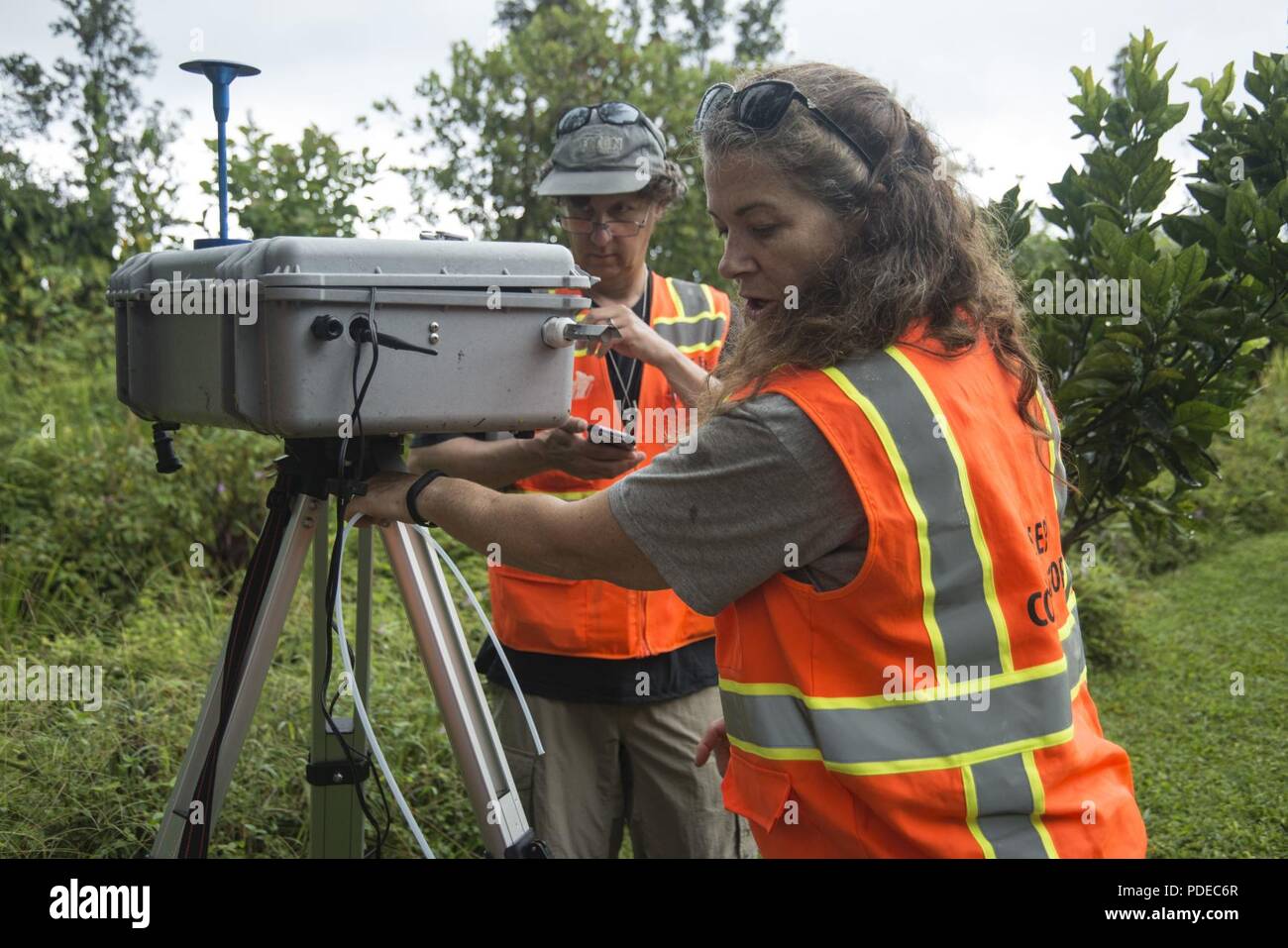 Pāhoa, Hawaii, 20. Mai 2018 - US Environmental Protection Agency (EPA) Auftragnehmer Ben Castellana (links) Amy Dubois (rechts) eine temporäre Air Monitoring System während des Kīlauea Vulkanausbruch installieren. Als Teil eines FEMA-Mission - Zuordnung, EPA arbeiten mit dem Hawaii Abteilung der Gesundheit ist Bewohnern zu helfen, sicher durch die Installation von Air Monitoring Stationen, die Daten über Schwefeldioxid, Schwefelwasserstoff zur Verfügung halten, und die partikelwerte. Stockfoto