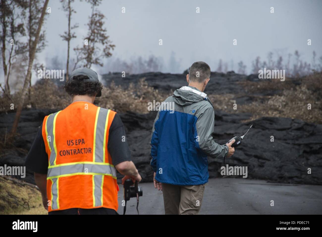 Pāhoa, Hawaii, 20. Mai 2018 - US Environmental Protection Agency (EPA) On-Scene Koordinator Jason Musante (rechts) Tests die Menge an Schwefeldioxid in der Luft während des Kīlauea Vulkanausbruch. Die Wohngegend von Leilani Estates hat sich durch Lava verschüttet, Erdbeben evakuiert worden, Feuer und hohe Konzentrationen von Schwefeldioxid. Als Teil eines FEMA-Mission - Zuordnung, EPA arbeiten mit dem Hawaii Abteilung der Gesundheit ist Bewohnern zu helfen, sicher durch die Installation von Air Monitoring Stationen, die Daten über Schwefeldioxid, Schwefelwasserstoff zur Verfügung halten, und die partikelwerte. Stockfoto